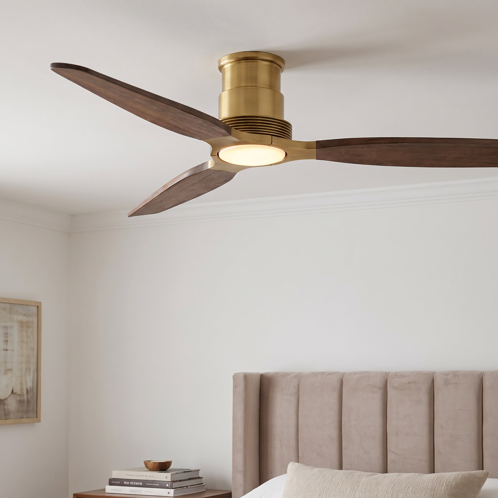 Modern ceiling fan with brass finish, dark wood blades, and integrated light.
