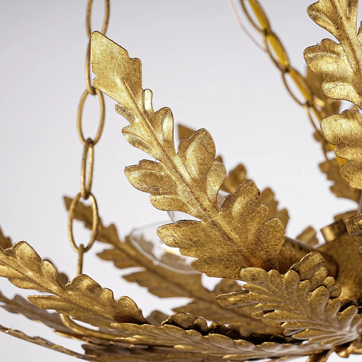 Close-up of an ornate gold leaf light fixture with decorative carved details
