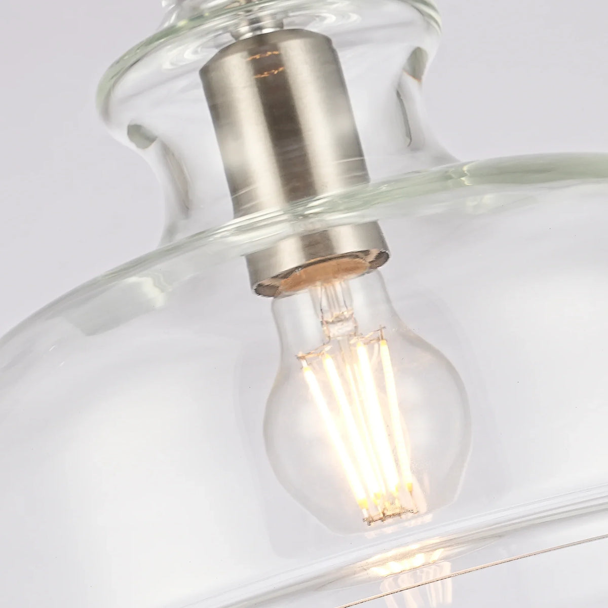 Close-up of a vintage-style filament light bulb inside a clear glass light fixture